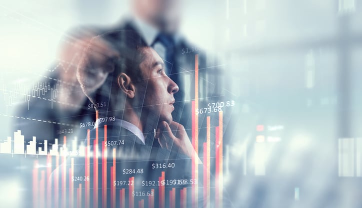 Exposure image of graphs and young thoughtful businessman looking away
