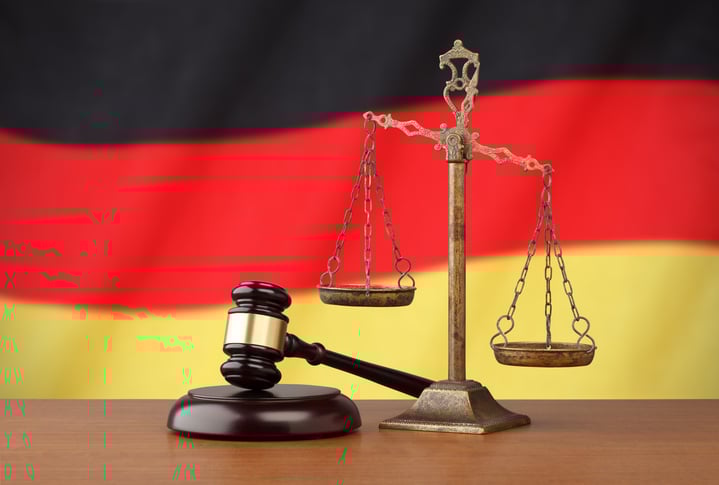 Germany’s flag and golden scale with a judges gavel