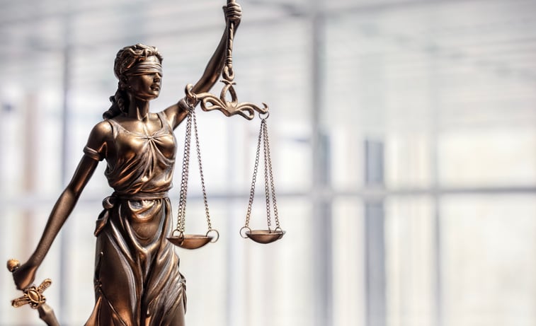 Lady Justice with scales of justice and office background