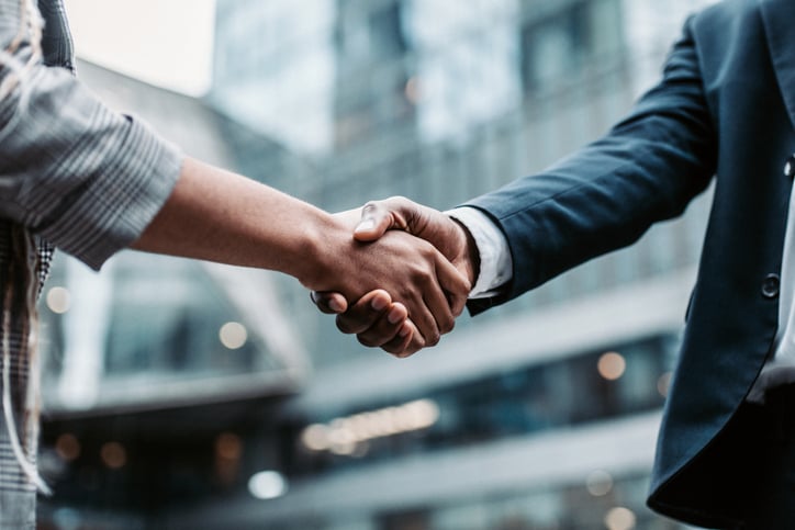 Meeting success. Two business persons shaking hands.